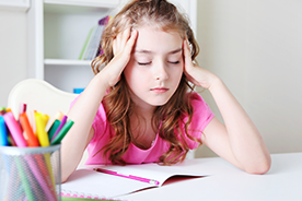 Girl holding her head with her eyes closed in discomfort